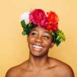 Woman smiling with headband of flowers.