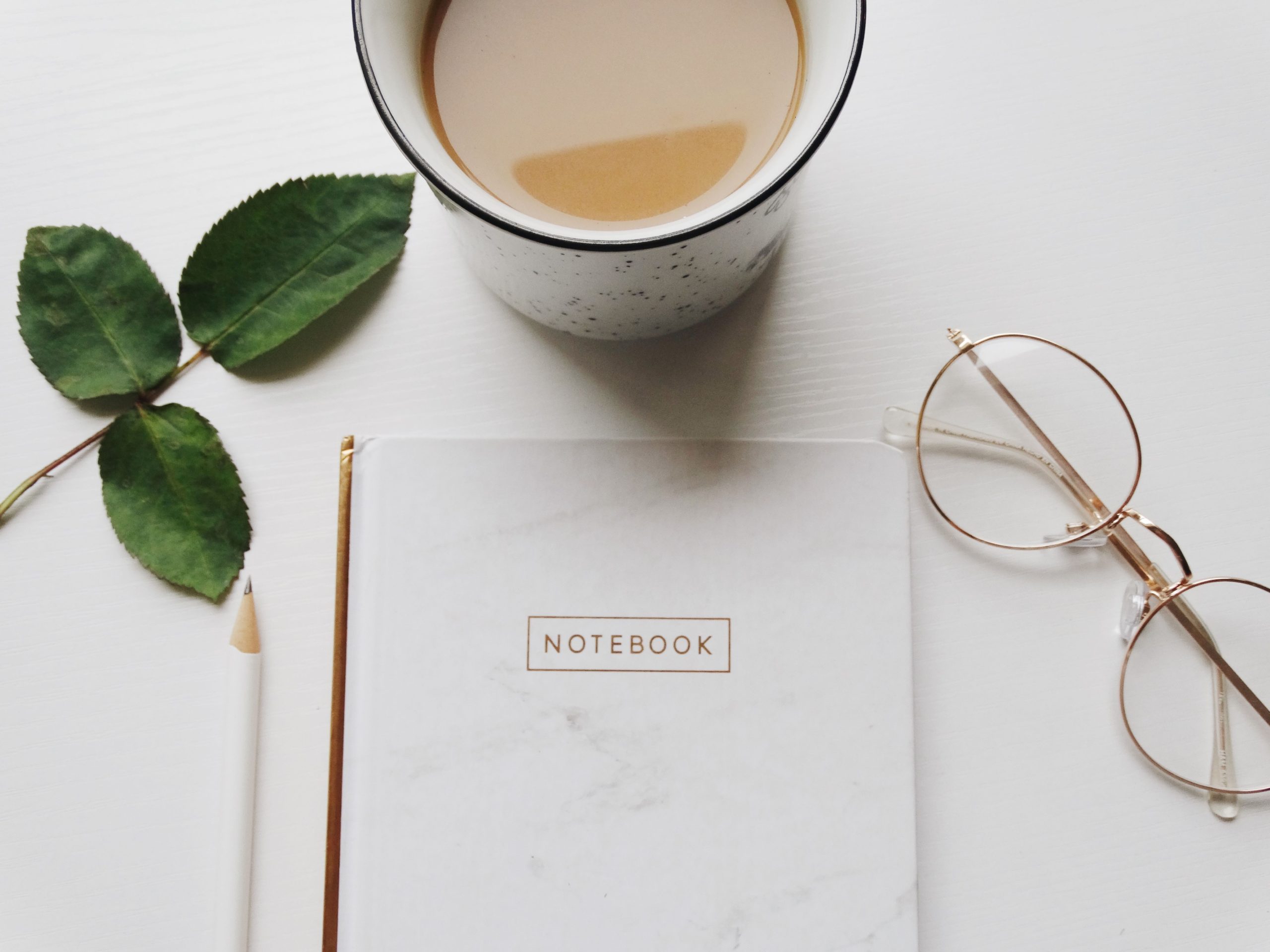 Notebook with glasses and cup of tea for personal day. 