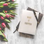 make it happen notebook for 10 life tips next to bundle of roses